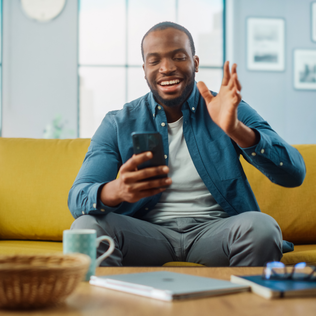 Man smiling at a phone during a video call.